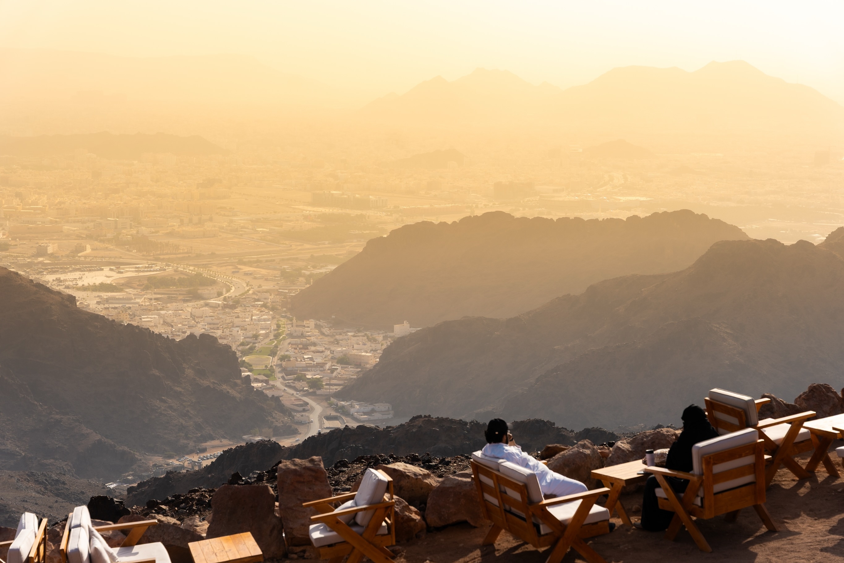 Visitors on the seating terrace high on Jabal Uhud, looking out over Madinah at sunset